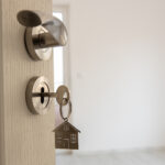 Open Door To A New Home. Door Handle With Key And Home Shaped Ke